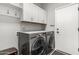 Laundry room with white cabinetry, shelving, and a modern washer and dryer at 3006 E Lexington Ave, Gilbert, AZ 85234