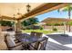 Covered patio with outdoor dining overlooking the well-maintained backyard with lush landscaping at 3006 E Lexington Ave, Gilbert, AZ 85234