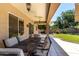 Covered patio with an outdoor dining set and a view of the landscaped backyard at 3006 E Lexington Ave, Gilbert, AZ 85234