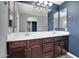 Modern bathroom with double vanity, white countertop, wood cabinets and stylish light fixture at 3036 N Acacia Way, Buckeye, AZ 85396