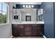Bathroom features a double sink vanity with dark wood cabinets and a large mirror at 3036 N Acacia Way, Buckeye, AZ 85396