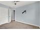 The bedroom includes neutral carpet, a ceiling fan, and entry to another room at 3036 N Acacia Way, Buckeye, AZ 85396