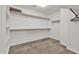 Walk-in closet featuring neutral carpet, wood shelving, and closet rods for optimal storage at 3036 N Acacia Way, Buckeye, AZ 85396