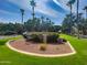 Lush neighborhood entrance featuring mature trees, flowers, and the 'Verrado Commons' community sign at 3036 N Acacia Way, Buckeye, AZ 85396