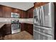 Close-up of a kitchen with stainless steel appliances and wooden cabinetry at 3036 N Acacia Way, Buckeye, AZ 85396