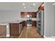 Gourmet kitchen featuring granite countertops, stainless appliances, and stylish wood-look tile flooring at 3036 N Acacia Way, Buckeye, AZ 85396