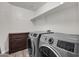 Spacious laundry room with modern washer and dryer, storage cabinet and tile floor at 3036 N Acacia Way, Buckeye, AZ 85396