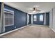 This main bedroom features multiple windows and neutral carpet flooring at 3036 N Acacia Way, Buckeye, AZ 85396