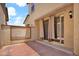 Back patio featuring brick pavers, stucco walls, and sliding glass doors leading to the indoors at 3036 N Acacia Way, Buckeye, AZ 85396