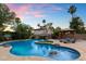 Resort-style backyard features a pool with waterfall, tropical landscaping, and covered cabana at 3944 W Paradise Ln, Phoenix, AZ 85053