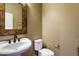 Elegant powder room featuring a pedestal sink, ornate mirror, and a toilet at 3944 W Paradise Ln, Phoenix, AZ 85053