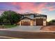 Stunning two-story home featuring a three-car garage and solar panels under a vibrant pink sunset at 3944 W Paradise Ln, Phoenix, AZ 85053