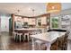 Open kitchen featuring brick accent wall, white cabinets, stainless steel appliances, and a dining area at 3944 W Paradise Ln, Phoenix, AZ 85053