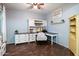Bright home office with built-in desk and shelving, wood floors, and a ceiling fan at 3944 W Paradise Ln, Phoenix, AZ 85053