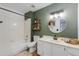 Cozy bathroom featuring olive green walls, a shower-tub combo, and a round mirror above a white vanity at 4772 W Joshua Blvd, Chandler, AZ 85226