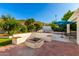 Backyard boasts a built-in seating area around a fire pit, lush landscaping, and mature trees at 507 W Sweetwater Ave, Phoenix, AZ 85029