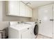Functional laundry room with washer, dryer, and overhead cabinets for storage at 507 W Sweetwater Ave, Phoenix, AZ 85029