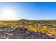 Wide neighborhood view showing homes and trees under a bright sky, captured from a rocky elevation at 507 W Sweetwater Ave, Phoenix, AZ 85029