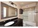 Bathroom featuring a black granite vanity, updated fixtures, framed mirror, and shower over tub at 6023 E Scafell Cir, Mesa, AZ 85215