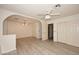 Spacious room featuring light wood floors and an arched doorway leading to an additional room at 6023 E Scafell Cir, Mesa, AZ 85215