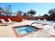 A hot tub spa sits adjacent to the community pool with lounge chairs and a decorative, orange fence at 6023 E Scafell Cir, Mesa, AZ 85215
