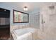 Bright main bathroom featuring soaking tub with tile surround and walk-in shower with glass block at 6023 E Scafell Cir, Mesa, AZ 85215