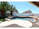 Backyard oasis featuring a pebble tec pool, rock waterfall, desert landscaping, and privacy wall at 6023 E Scafell Cir, Mesa, AZ 85215