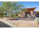 Elegant clubhouse entrance with stone accents, mature tree, and manicured landscaping at 7315 E Brisa Dr, Scottsdale, AZ 85266