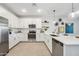 Bright kitchen with white cabinets, stainless steel appliances, quartz countertops, and stylish backsplash at 7439 S 76Th Dr, Laveen, AZ 85339