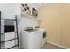 Efficient laundry room with modern washer and dryer, stylish wallpaper and storage shelves at 7439 S 76Th Dr, Laveen, AZ 85339