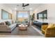 Well-lit living room with a comfortable gray sectional, stylish decor, and contemporary accents at 7439 S 76Th Dr, Laveen, AZ 85339