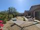 Landscaped backyard with a hammock, lounge chairs, and mature desert landscaping at 7722 E Wolf Canyon St, Mesa, AZ 85207