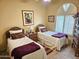 Cozy bedroom with twin beds, a ceiling fan, neutral walls, and a window with natural light at 7722 E Wolf Canyon St, Mesa, AZ 85207