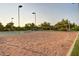Outdoor sand volleyball court surrounded by greenery, benches, and lighting for residents to enjoy this amenity at 7722 E Wolf Canyon St, Mesa, AZ 85207