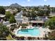 Community pool with lush landscaping and lounge seating in a well-maintained desert community with mountain views at 7955 E Chaparral Rd # 129, Scottsdale, AZ 85250