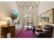 Bright living room featuring a large mirror, television, treadmill, leather chairs, and a patterned rug at 7955 E Chaparral Rd # 129, Scottsdale, AZ 85250