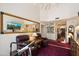 Bright living area featuring a television, mirror, recliners, treadmill, and a glimpse into the hallway at 7955 E Chaparral Rd # 129, Scottsdale, AZ 85250