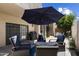 Relaxing outdoor patio with comfortable chairs, a large sun umbrella, a grill and well-maintained desert landscaping at 7955 E Chaparral Rd # 129, Scottsdale, AZ 85250