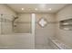 Modern shower with pebble flooring, neutral tiles, built-in bench, and glass partition for a sleek design at 7955 E Chaparral Rd # 129, Scottsdale, AZ 85250