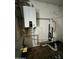 Mechanical room featuring a modern tankless water heater with visible pipes and fixtures against a white block wall at 8257 E Cypress St, Scottsdale, AZ 85257