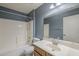 Well-lit bathroom features a shower-tub combo, white tile, and a vanity with a large mirror at 8660 E Nido Ave, Mesa, AZ 85209