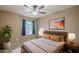 Cozy bedroom featuring a bed, bedside tables, natural light, and a ceiling fan at 8660 E Nido Ave, Mesa, AZ 85209