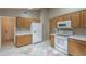 Kitchen features white appliances, tile floors, and wood cabinets at 8660 E Nido Ave, Mesa, AZ 85209