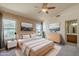 Bright main bedroom featuring a ceiling fan, natural light, and an attached ensuite bathroom at 8660 E Nido Ave, Mesa, AZ 85209