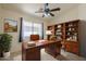 Home office with a wooden desk, bookcase, ceiling fan and natural light at 8660 E Nido Ave, Mesa, AZ 85209
