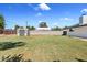 Home's grassy backyard featuring a brick perimeter wall and exterior storage building at 1050 W 9Th Pl, Mesa, AZ 85201