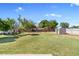 Home's backyard featuring a well-maintained lawn, brick perimeter wall, and exterior storage building at 1050 W 9Th Pl, Mesa, AZ 85201
