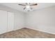 Bright bedroom featuring a ceiling fan, closet with white doors and wood-look flooring at 1050 W 9Th Pl, Mesa, AZ 85201
