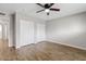 Bright bedroom featuring wood floors, ceiling fan, and a closet for ample storage at 1050 W 9Th Pl, Mesa, AZ 85201
