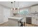 Bright kitchen features an island with a quartz countertop, modern appliances, and backsplash at 1050 W 9Th Pl, Mesa, AZ 85201